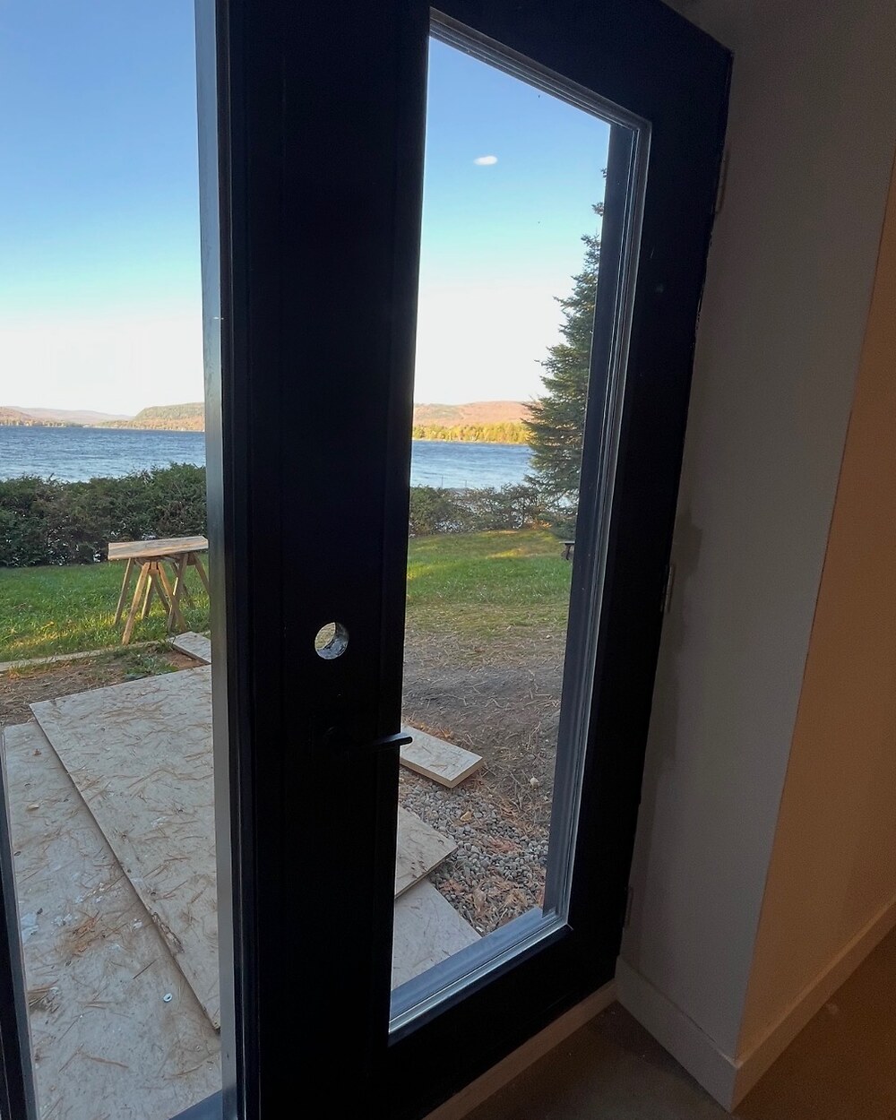 Porte vitrée propre avec vue claire sur le lac, après nettoyage par Lavopro